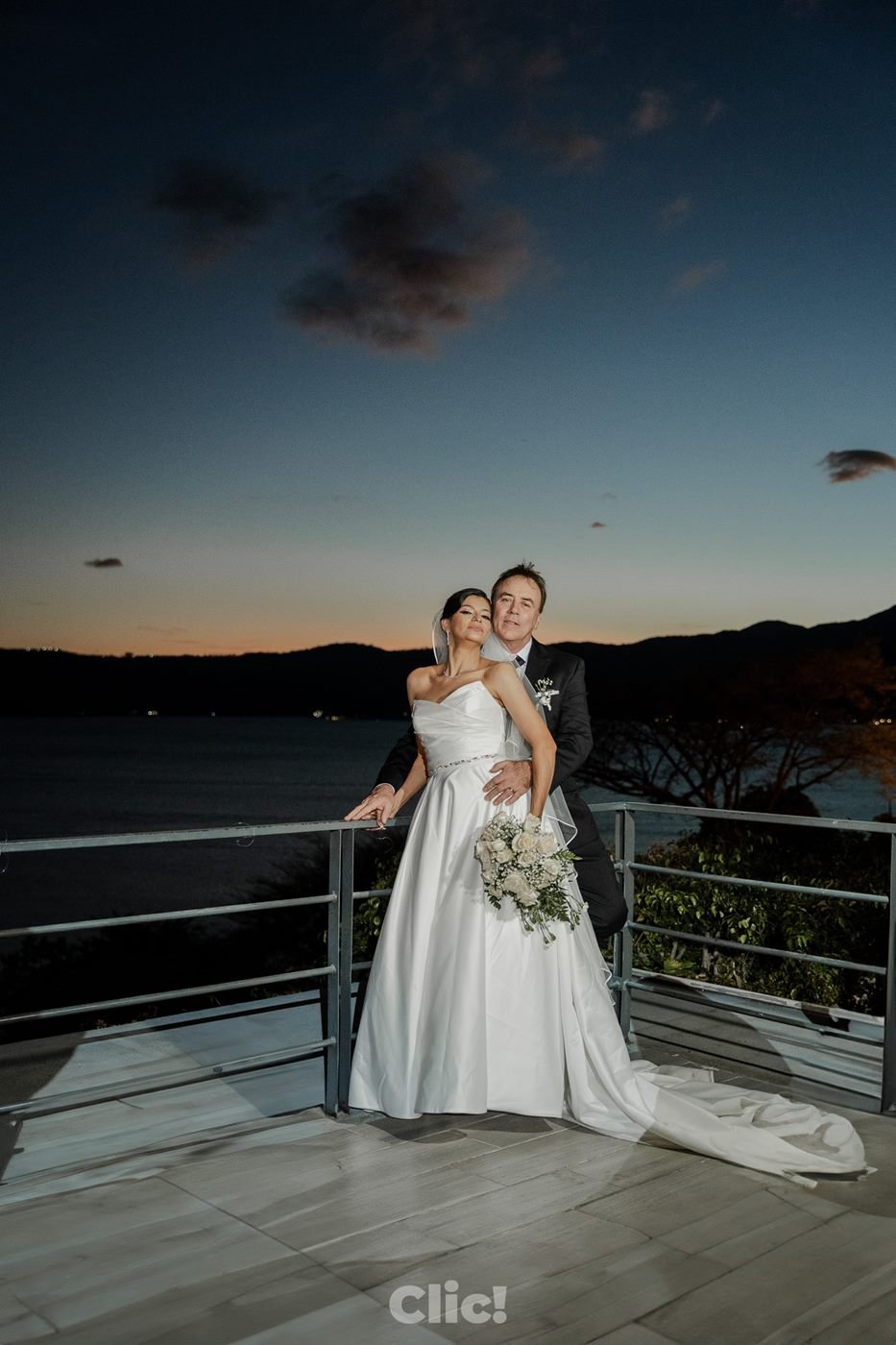 Novios al atardecer en un mirador sobre un lago