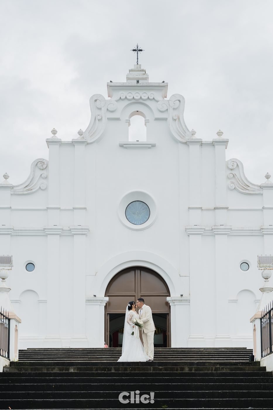 Novios frente a una iglesia colonial blanca
